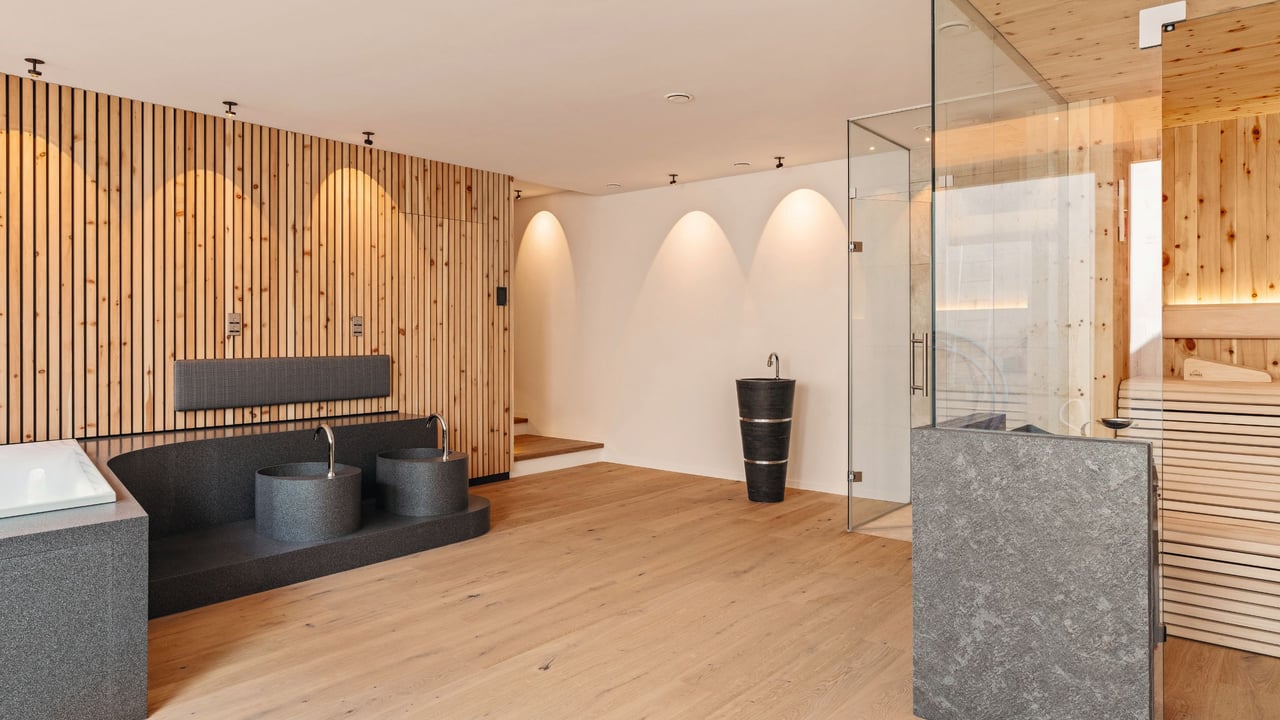 Wellness-Oase-Mineralwerkstoff-Waschtisch-Anlage-Holzlamellenwand-Sauna-Glastrennwand-innenarchitektur