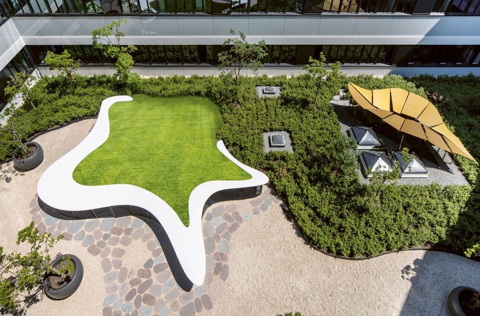 Hasenkopf-Projekte-DZ-HYP-Innenhof-geschwungener-Stehtresen-aus-Mineralwerkstoff-mit-Begruenung