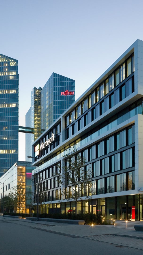 Microsoft-Logo-auf-Gebauede-mit-Corian-Seitenwaenden-am-Abend Microsoft-Logo-auf-Gebauede-mit-Corian-Seitenwaenden-am-Abend