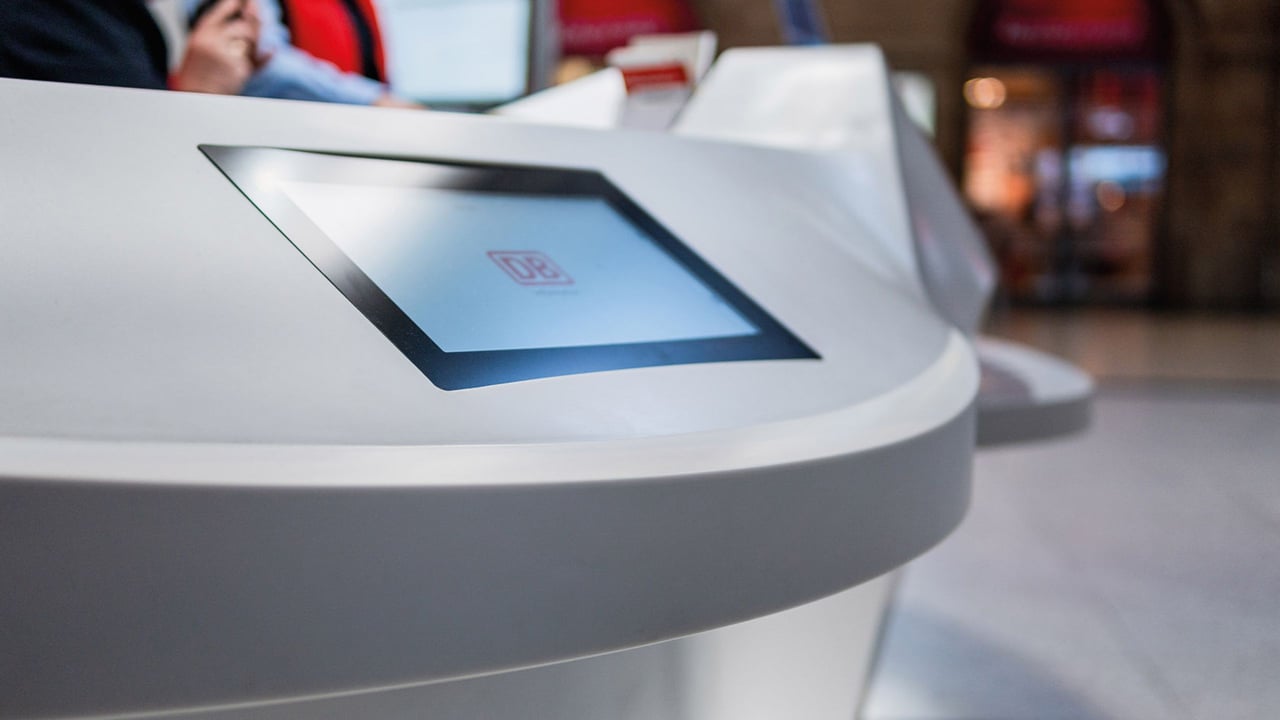 Detailaufnahme-einer-glatten-Corian-Infotheke-der-Deutschen-Bahn-mit-eingelassenem-Bildschirm