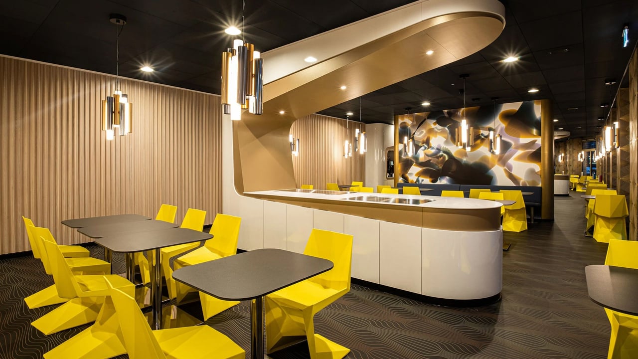 Prizeotel-Erfurt-Lounge-Mineralwerkstoff-Theke-fugenlos-gelbe-Stuehle-Holzlamellen-Wand-Gastronomie