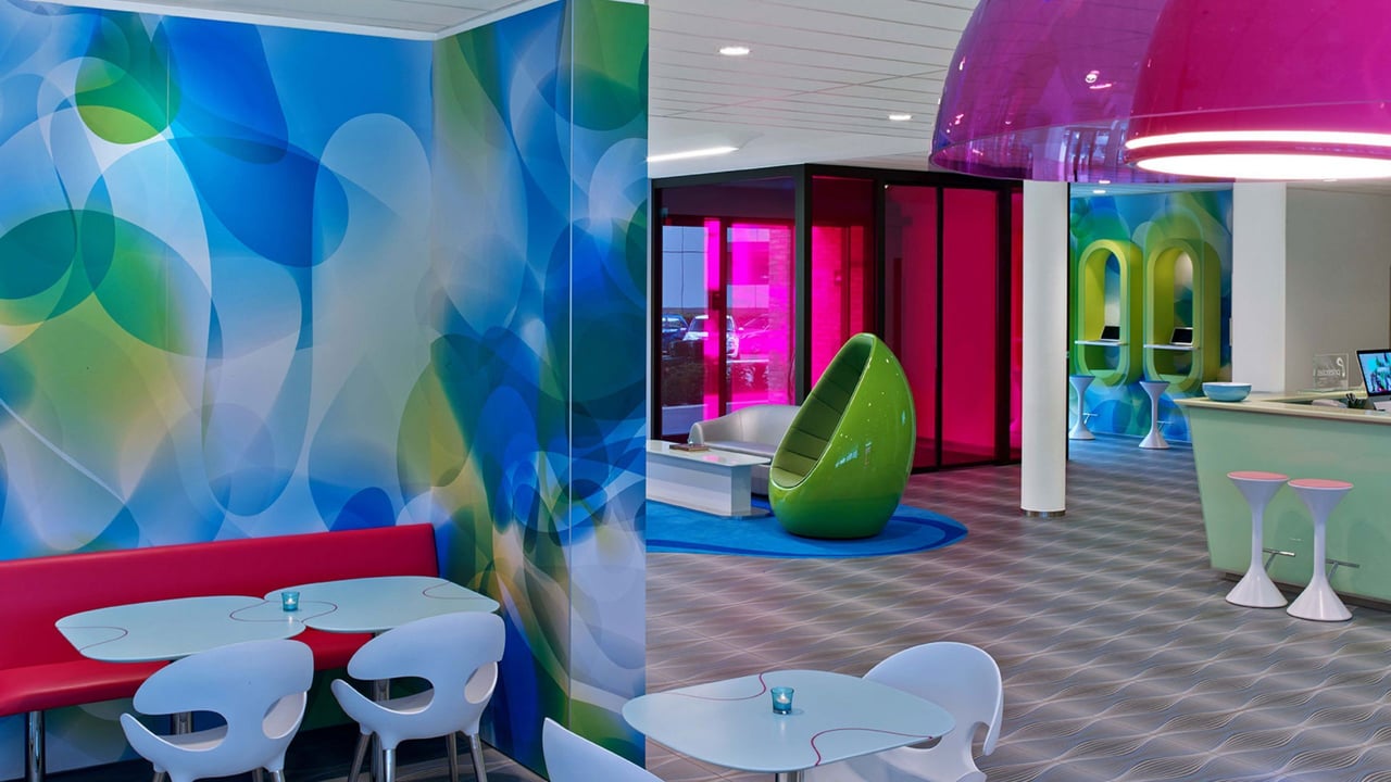 Prizeotel-Hamburg-City-Lounge-Mineralwerkstoff-Tischplatten-bunte-Wandgestaltung-sitzmoebel-designstuhl