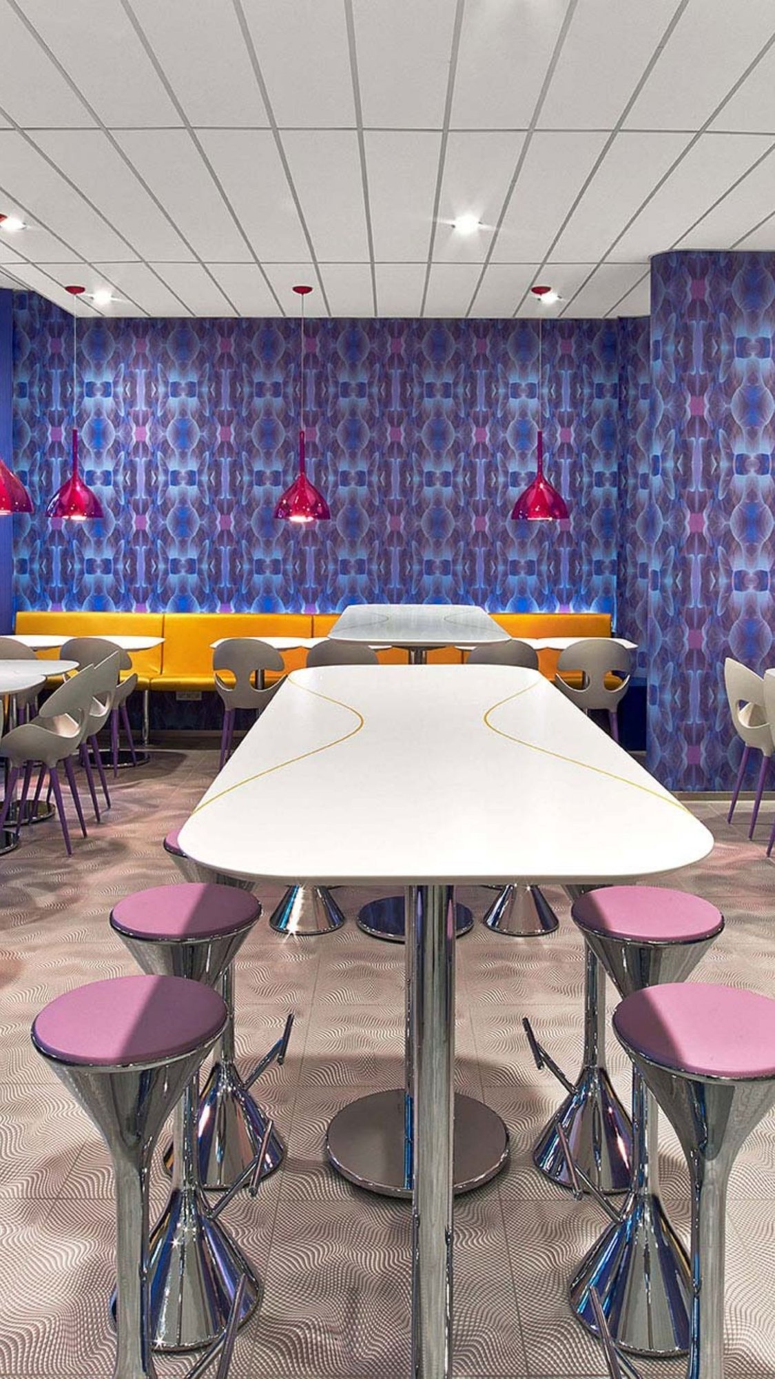 Prizeotel-Restaurant-Hochformat-Mineralwerkstoff-Tischplatte-Sitzecke-bunte-tapete-design-hocker
