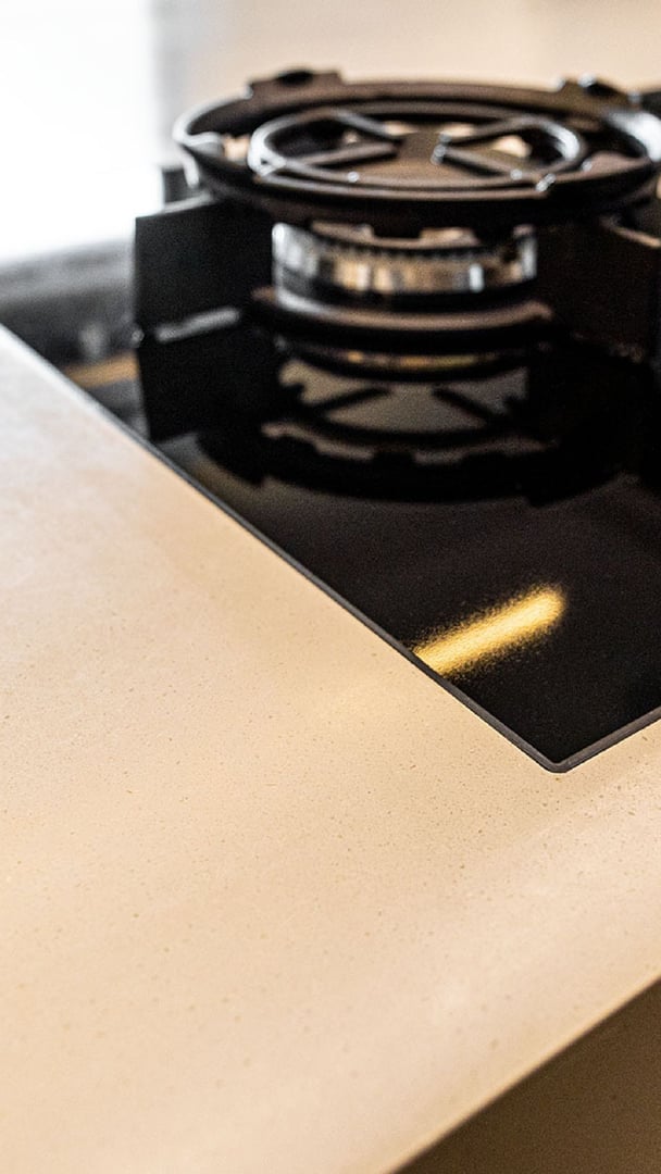 Detailaufnahme-des-fugenlosen-Uebergangs-von-Corian-Arbeitsflaeche-zu-einem-Gas-Kochfeld