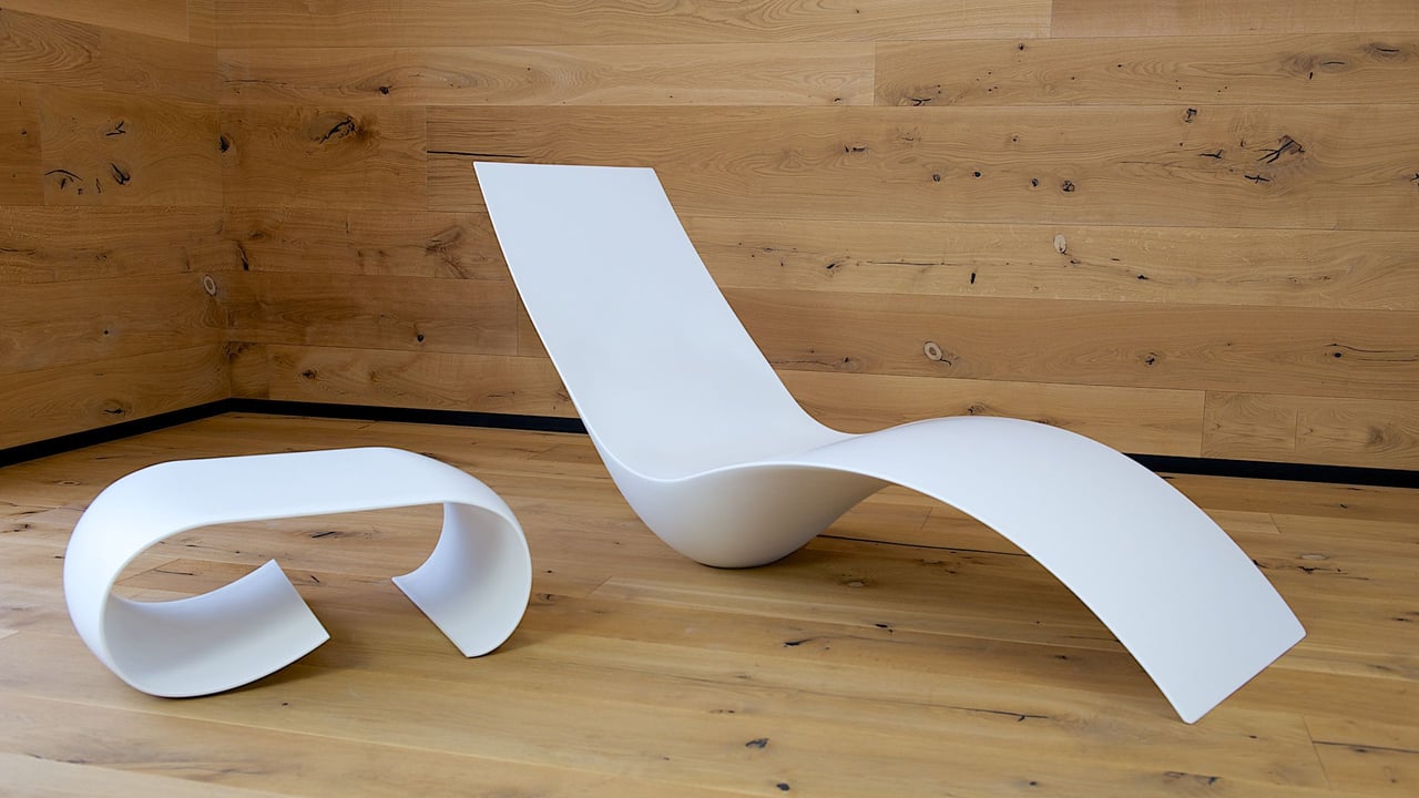 futuristisch-geformter-liegestuhl-mit-weißem-nachtisch-aus-mineralwerkstoff