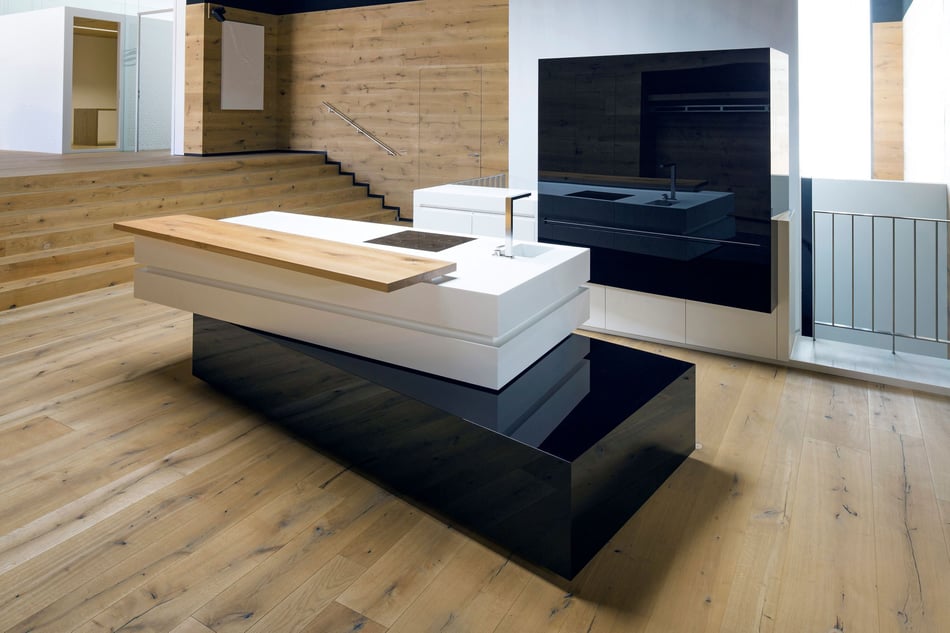 Moderne-Hasenkopf-Showkueche-mit-schwarzer-und-weisser-Kuecheninsel-aus-Mineralwerkstoff-und-Holzelementen