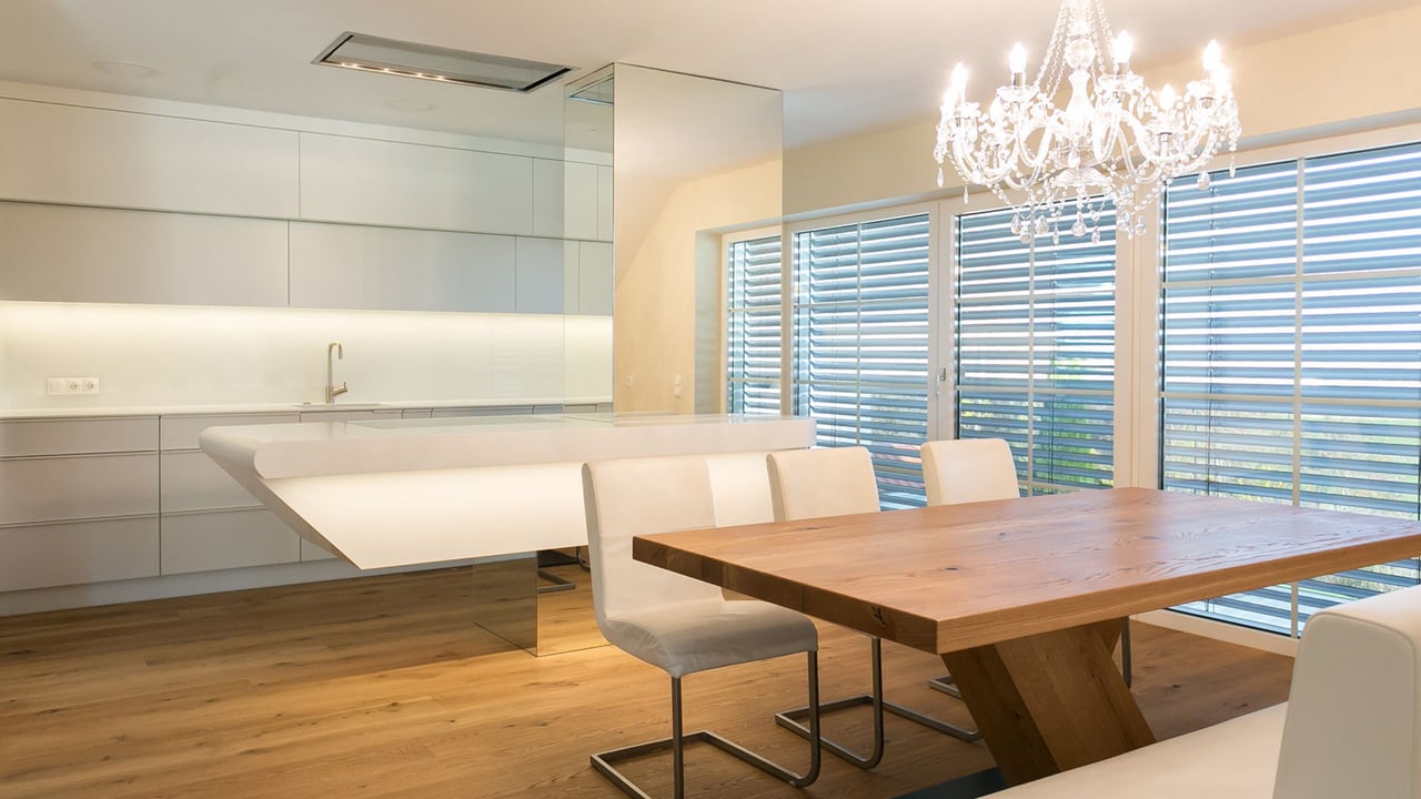 Weisse-Kueche-mit-schwebender-Corian-Insel-gefertigt-von-Hasenkopf-und-Essbereich-mit-Holztisch