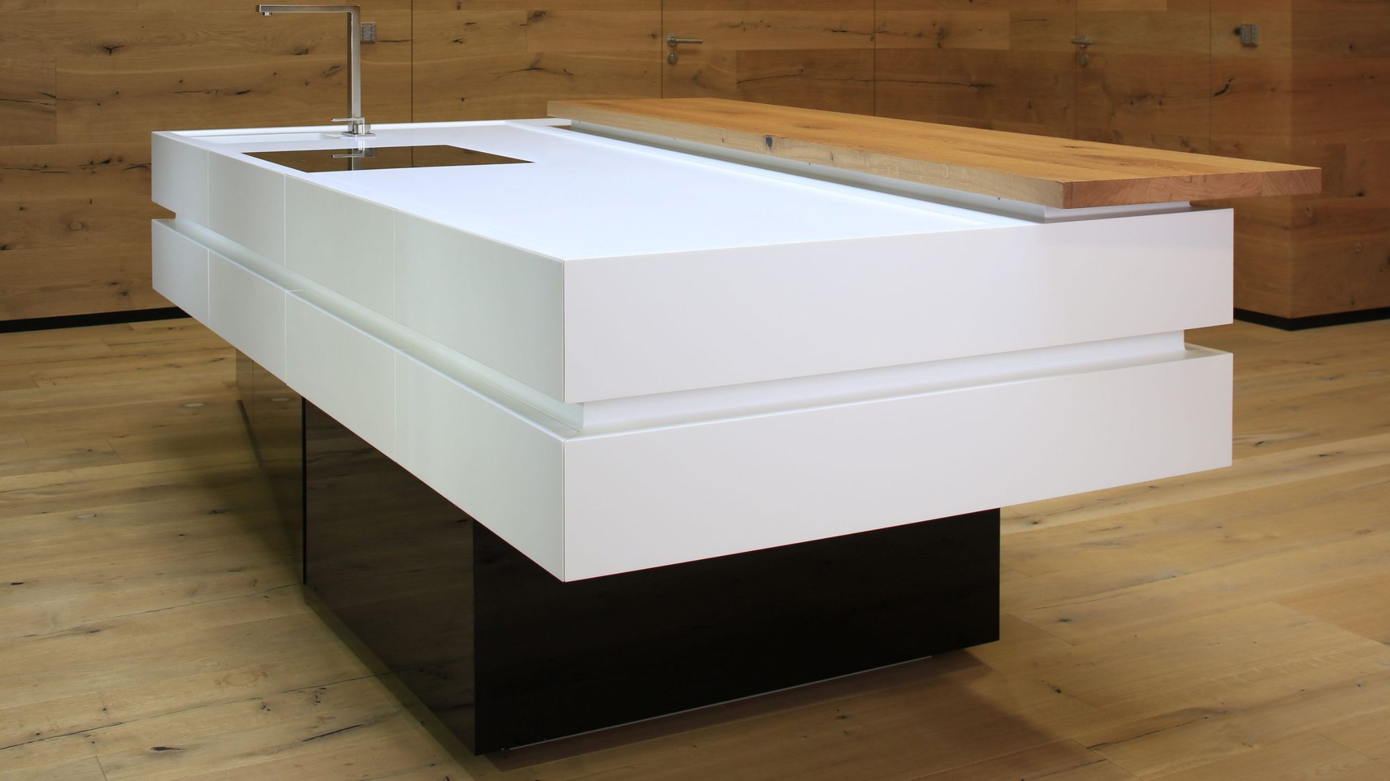 Schwebende-Kuecheninsel-mit-weisser-Corian-Platte-und-abgesetztem-Holzelement Schwebende-Kuecheninsel-mit-weisser-Corian-Platte-und-abgesetztem-Holzelement