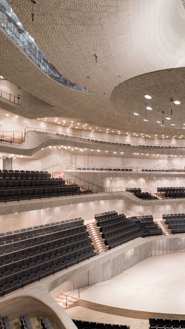 Vertikale-Ansicht-des-leeren-Konzertsaals-der-Elbphilharmonie-mit-der-weissen-Oberflaeche-aus-GIFAtec-und-dunklen-Sitzen Vertikale-Ansicht-des-leeren-Konzertsaals-der-Elbphilharmonie-mit-der-weissen-Oberflaeche-aus-GIFAtec-und-dunklen-Sitzen