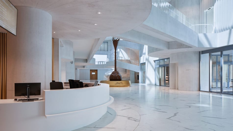 Atrium-mit-weißer-Mineralwerkstoff-Empfangstheke-und-Schokoladenbrunnen-im-Lindt-Home-of-Chocolate