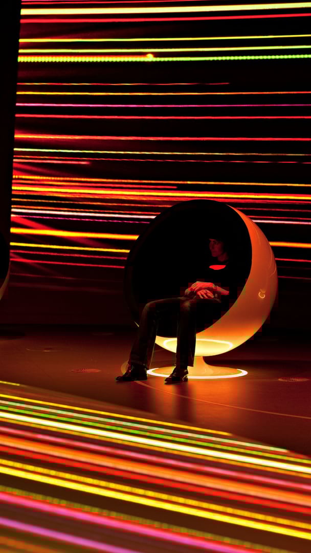 Besucher im immersiven Ausstellungsraum des CERN mit spektakulär beleuchteten Corian-Balls und Projektionen Besucher im immersiven Ausstellungsraum des CERN mit spektakulär beleuchteten Corian-Balls und Projektionen