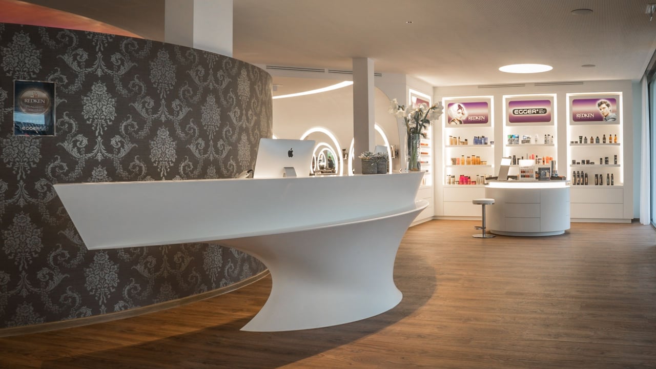 Futuristische Corian-Theke im Beauty-Salon Egger³, flankiert von einer Flagship-Produktpräsentation mit LED-Beleuchtung
