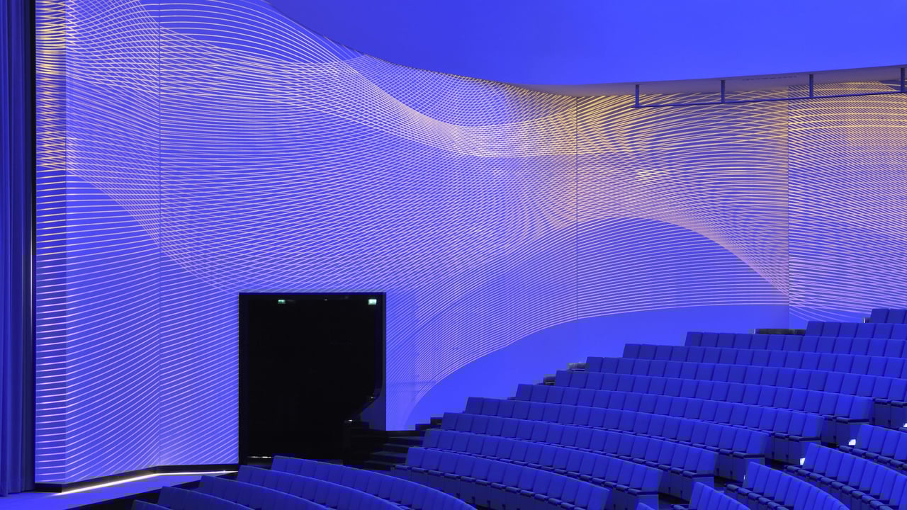 Akustikwand-mit-wellenfoermigen-Lichtlinien-in-Blau-und-Gelb-im-Konzertsaal-des-Forums-Usbekistan