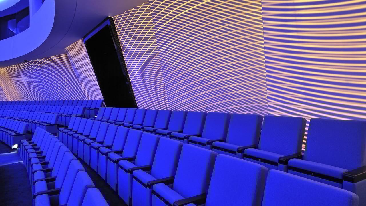 nnenansicht-des-Konzertsaals-im-Kongress-Taschkent-in-warmem-Rot-und-Orange-mit-geschwungenen-Sitzreihen-und-Balkonen