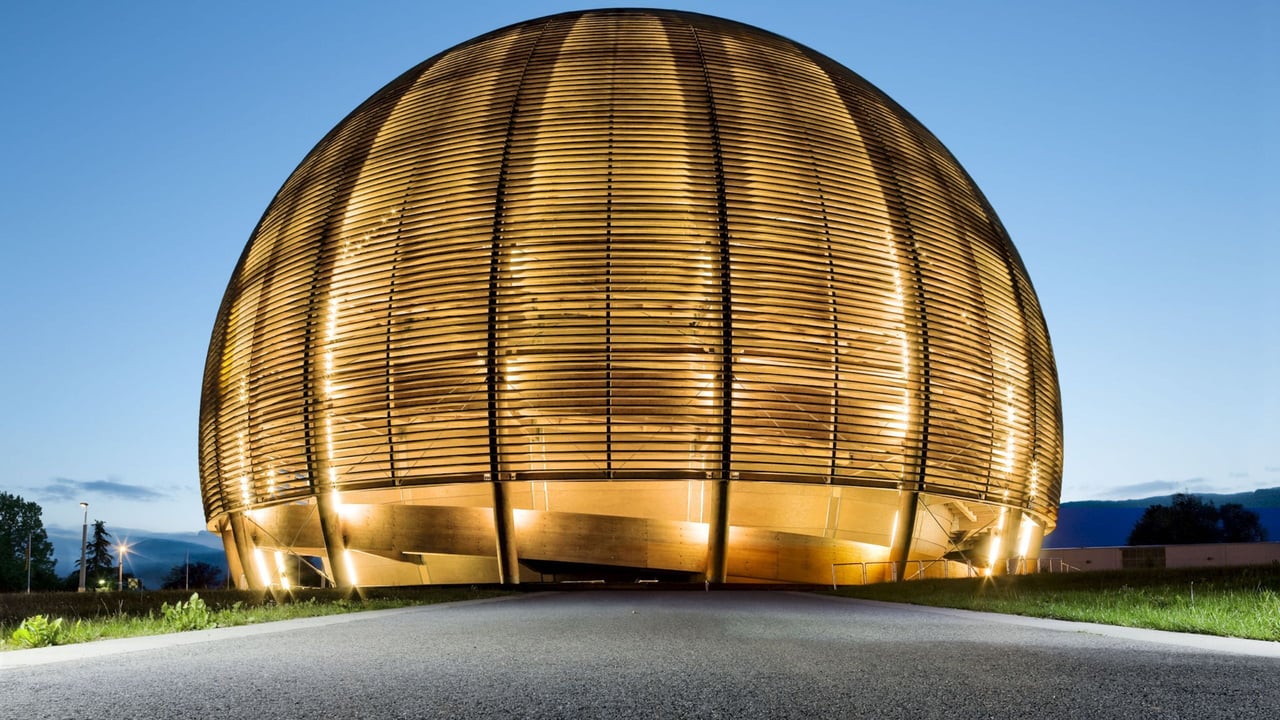 Außenansicht der beleuchteten Kugelstruktur des CERN-Besucherzentrums im Abendlicht