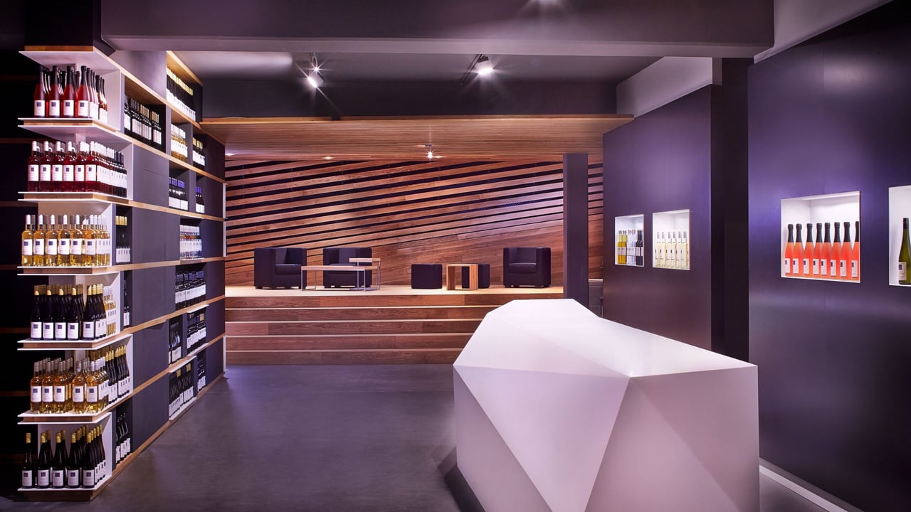 Innenraum der Vinothek Weinkorb Remstal mit kubistischer Corian-Theke als zentralem Blickfang