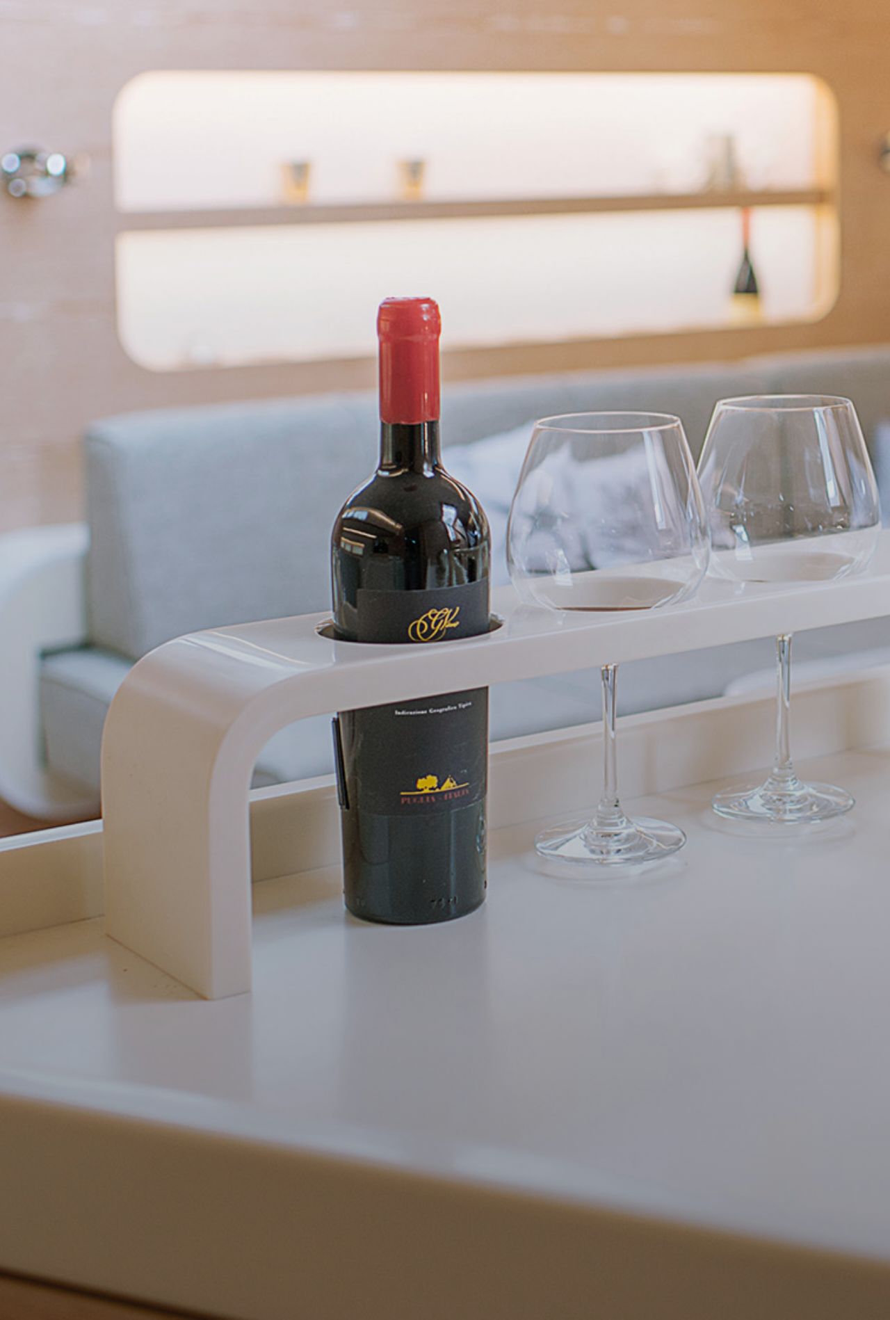 Weinflasche-und-Glaeser-auf-Tisch-aus-mineralwerkstoff-in-Halterung-in-moderner-Wohnmobil-Einrichtung