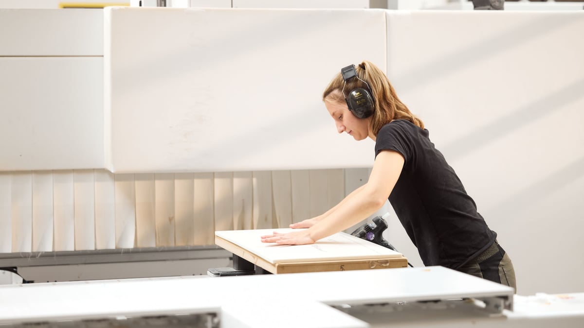 Mitarbeiterin-bei-Hasenkopf-begutachtet-ein-grosses-Corian-Bauteil-in-der-Werkstatt