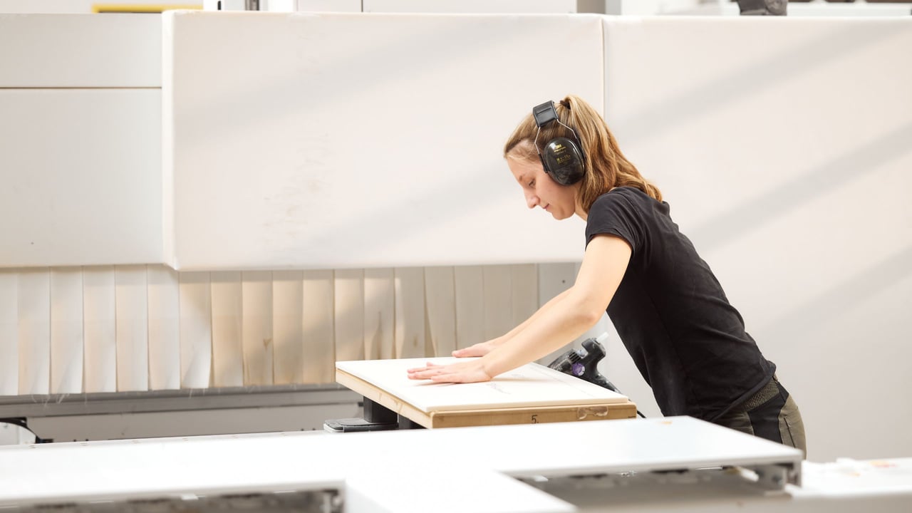 Mitarbeiterin-bei-Hasenkopf-begutachtet-ein-grosses-Corian-Bauteil-in-der-Werkstatt