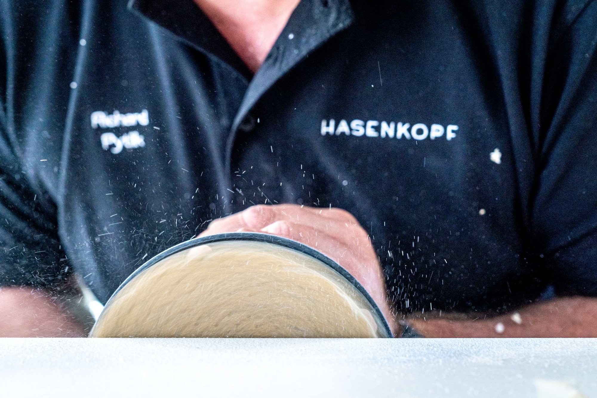 Schleifen-einer-Mineralwerkstofffläche-durch-einen-Hasenkopf-Mitarbeiter Schleifen-einer-Mineralwerkstofffläche-durch-einen-Hasenkopf-Mitarbeiter