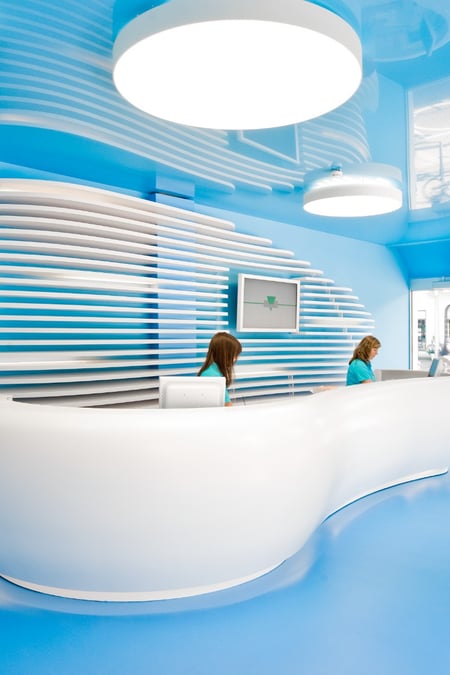 Moderne-Praxistheke-Praxis-Schnorbach-aus-Corian-in-weiß-mit-dynamisch-geschwungener-Front