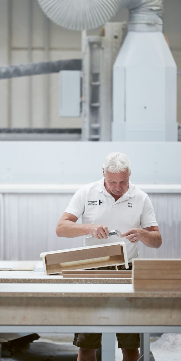 Hasenkopf-Mitarbeiter-bei-der-Prüfung-und-Nachbearbeitung-eines-Mineralwerkstoff-Teils